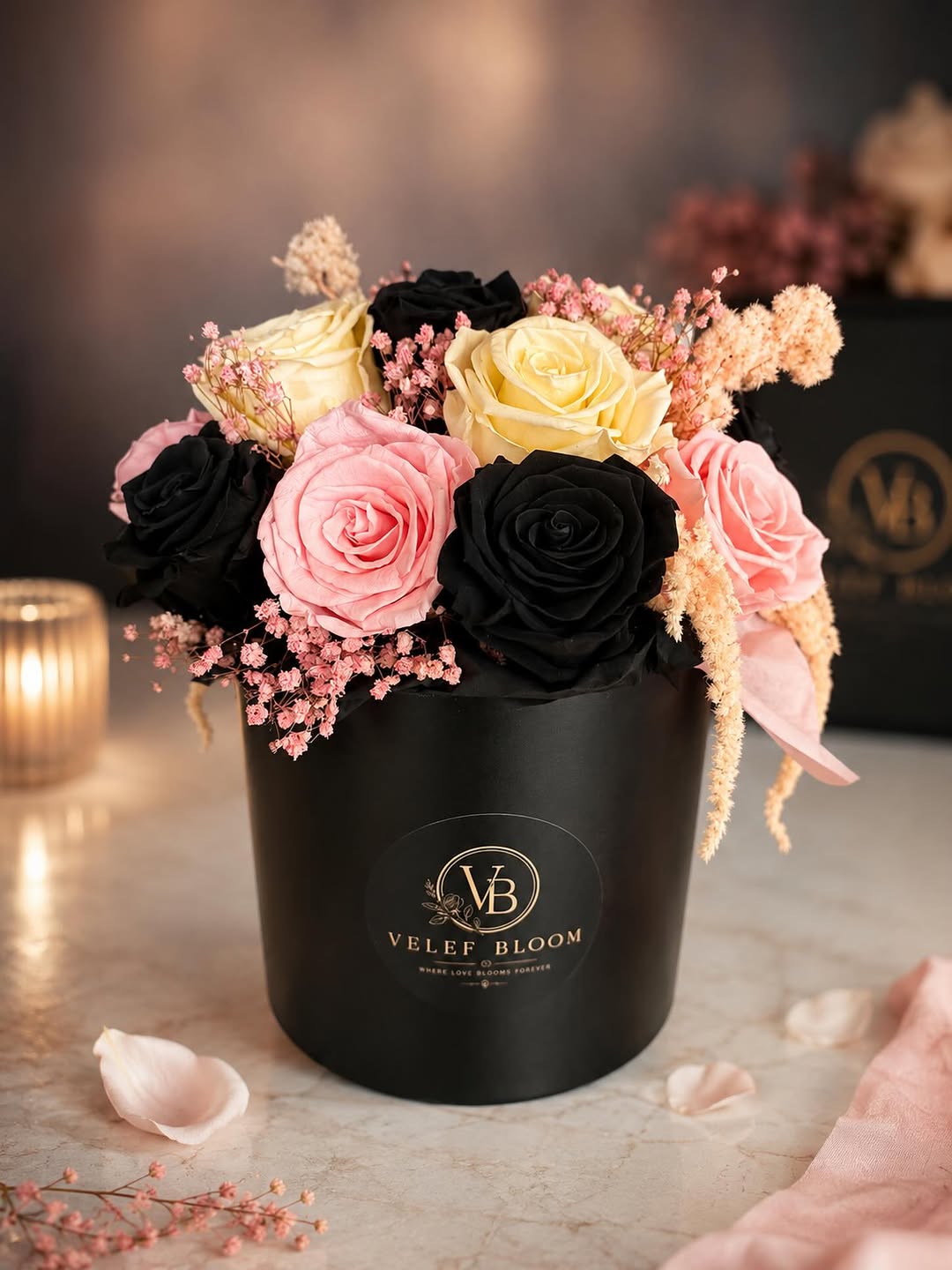 Signature arrangement of black, blush and cream preserved roses in a black Velef Bloom vessel on marble