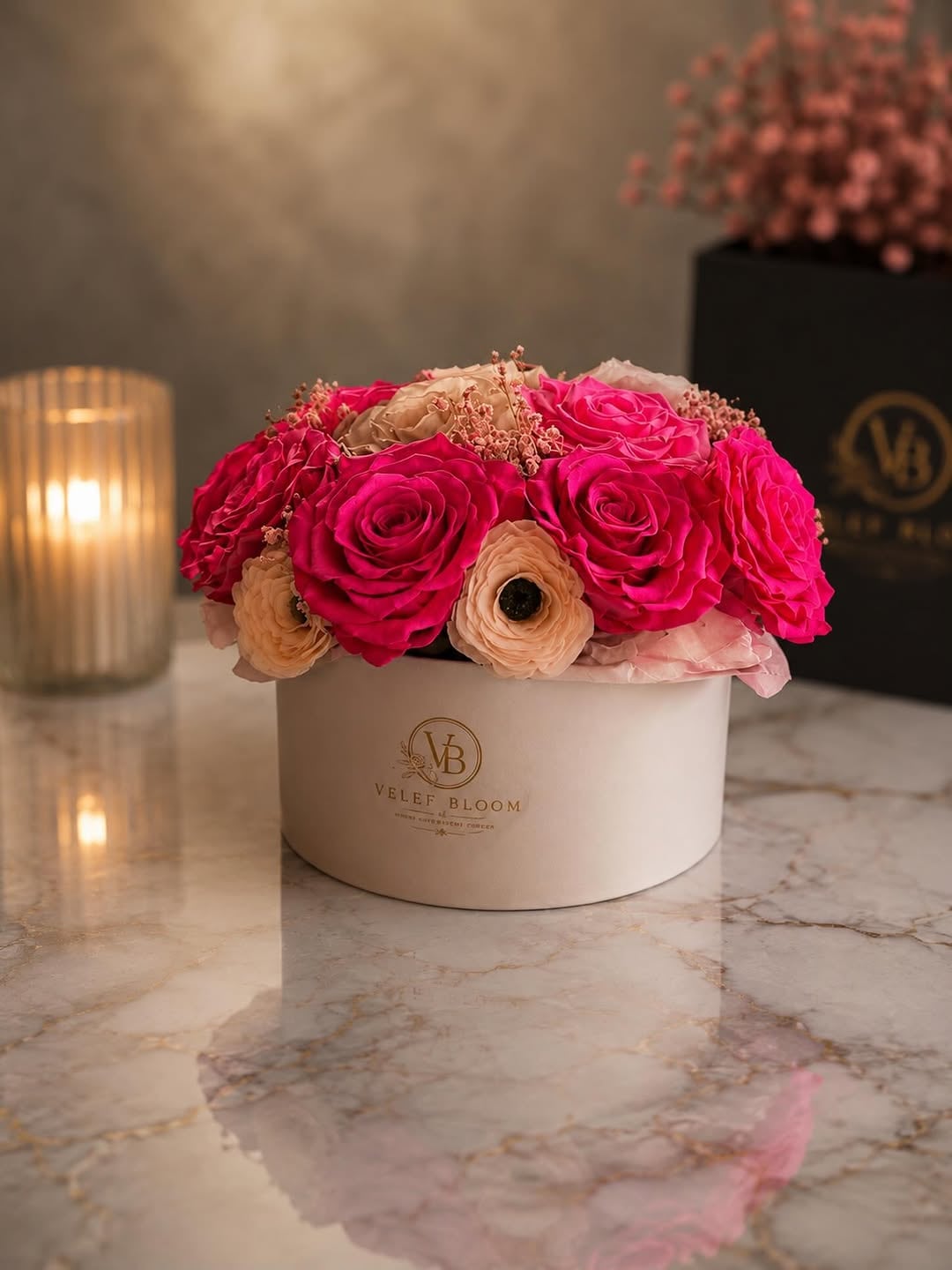 Grand arrangement of hot pink and champagne preserved roses spread across a wide white Velef Bloom ceramic bowl on marble